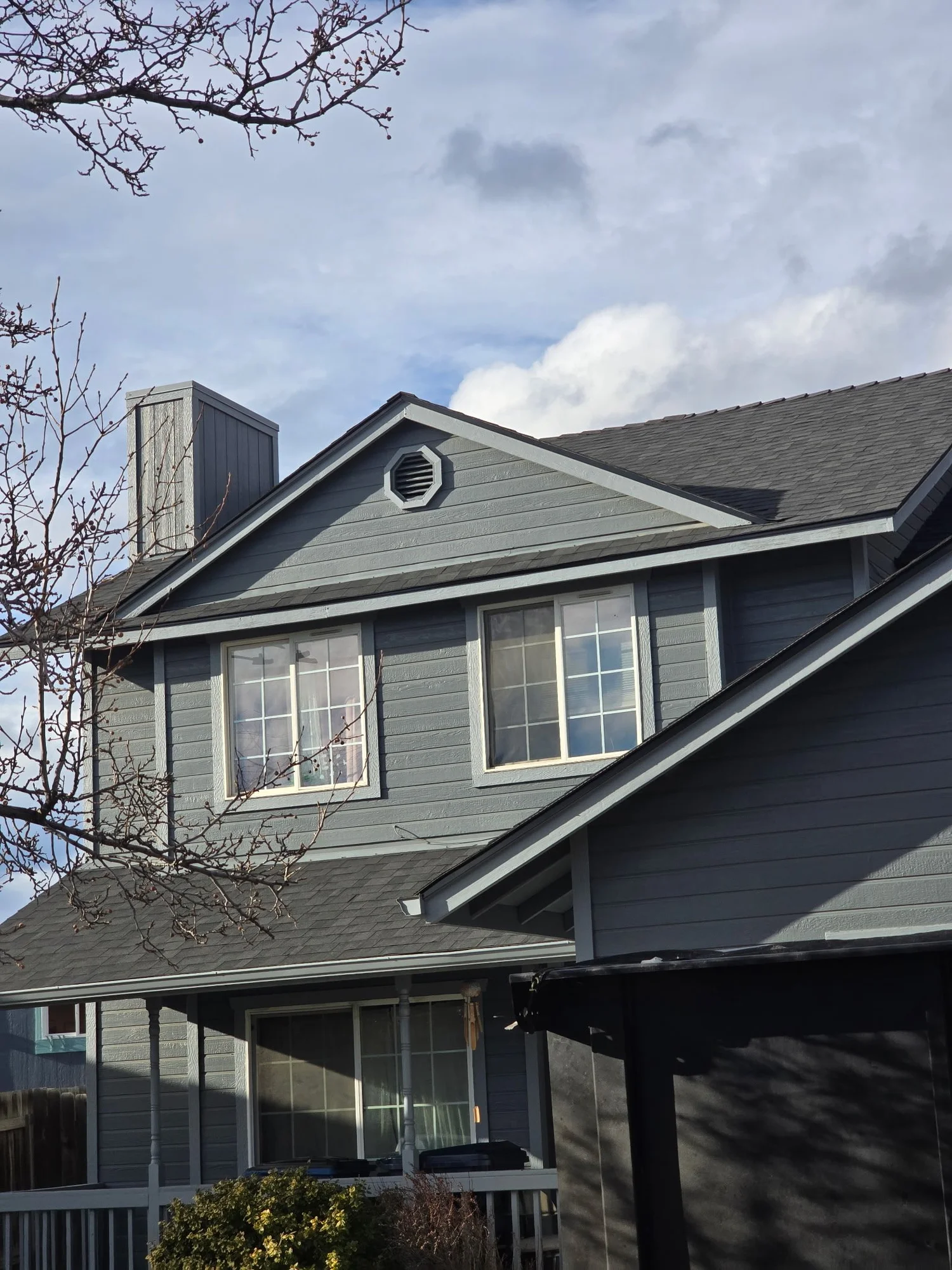 Shingle roofing on a gray home, from Willie Farias Celestino Roofing’s project gallery