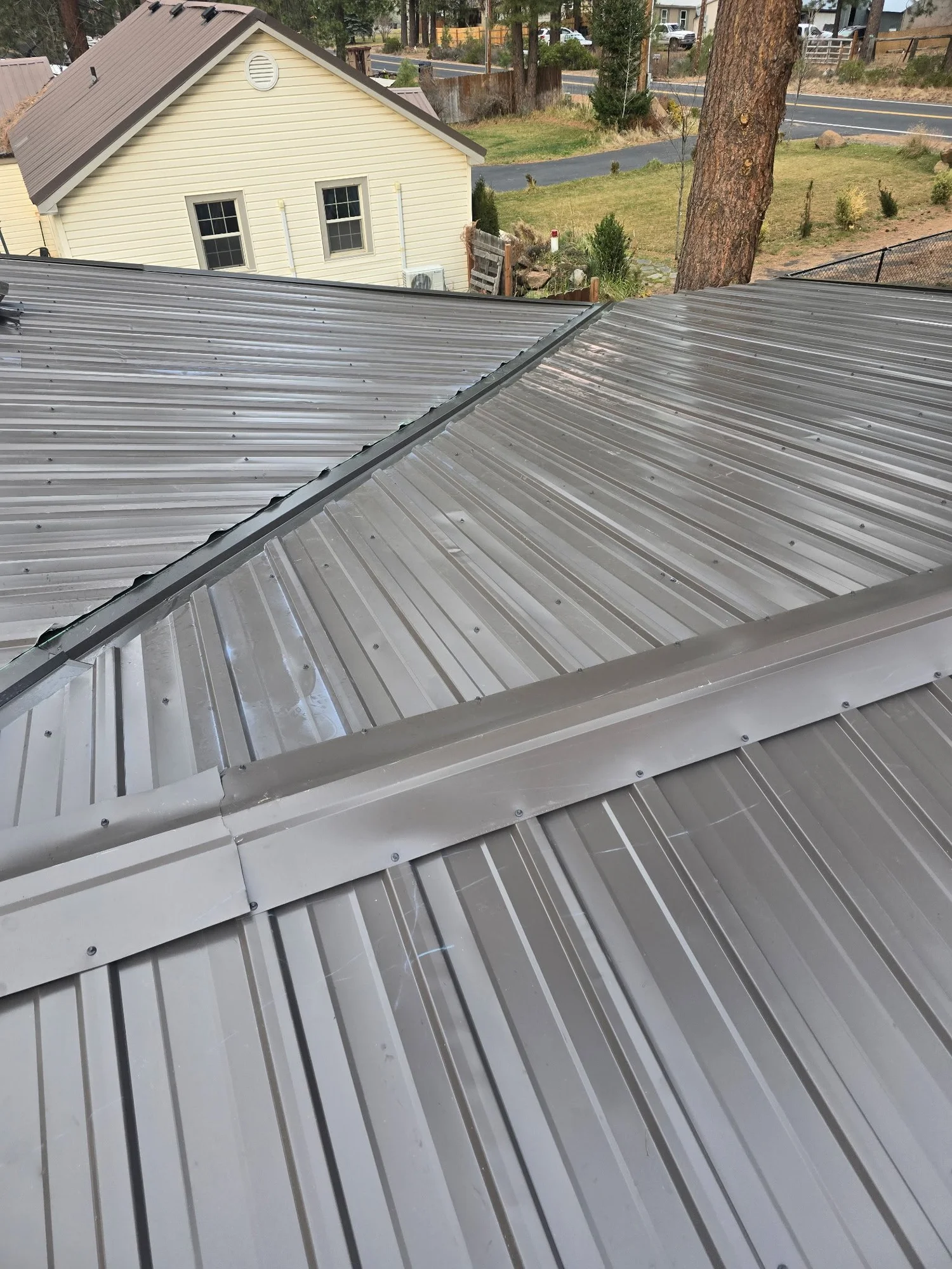 Metal roofing showing panel seams and roof transitions